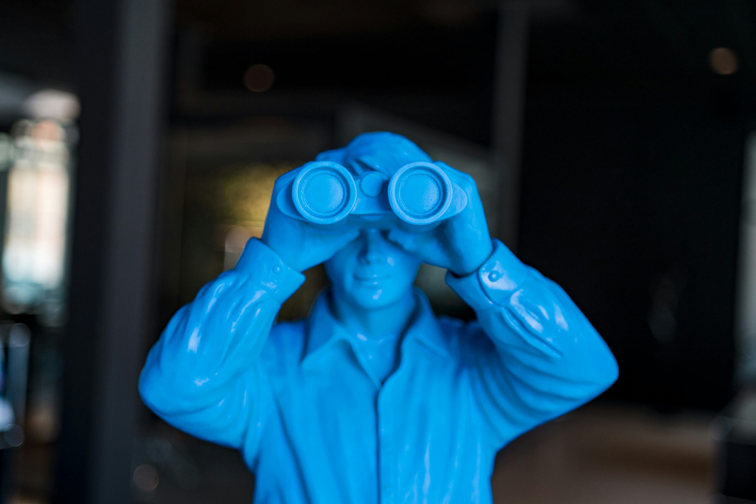 Blue statute with binoculars for mystery genre