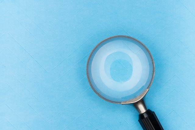Magnifying glass on a blue background to represent finding